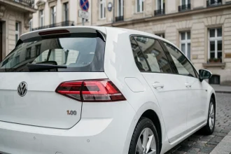 Badge 1.0 TSI sur une Volkswagen Golf blanche garée dans une rue urbaine européenne